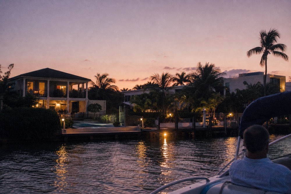 A riverboat cruising past waterfront homes at dusk, no text, no logos, no people