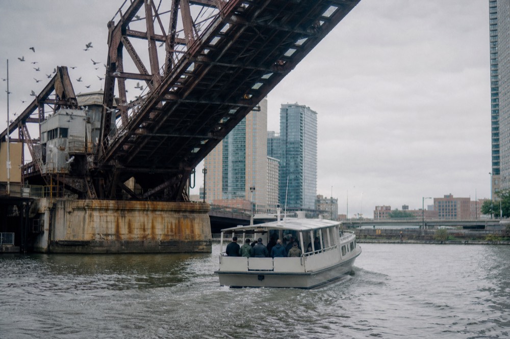 A water taxi passing under a raised drawbridge on the New River in downtown Fort Lauderdale, no text, no logos, no people