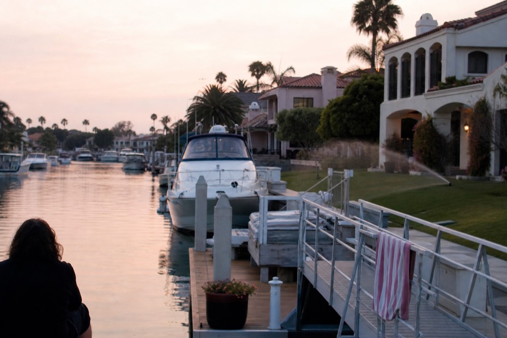 Waterfront homes and yachts along a Fort Lauderdale canal in early evening light, no text, no logos, no people