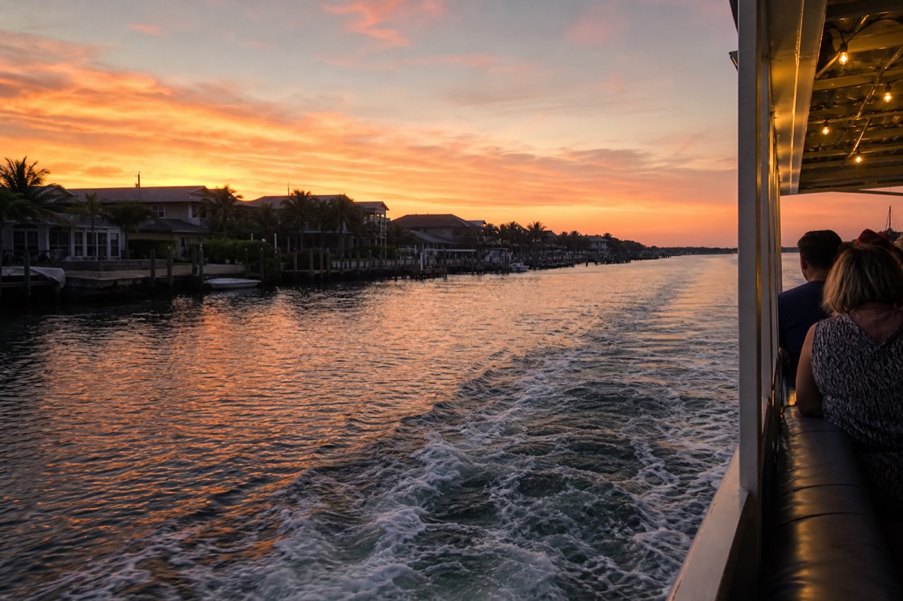 A boat cruising the Intracoastal Waterway at sunset past waterfront homes, no text, no logos, no people.