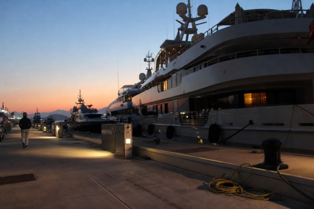 Superyachts tied up along a Fort Lauderdale marina wall at dusk, no text, no logos, no people