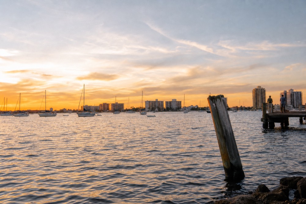 Golden hour light over the Intracoastal Waterway with boats and skyline, no text, no logos, no people