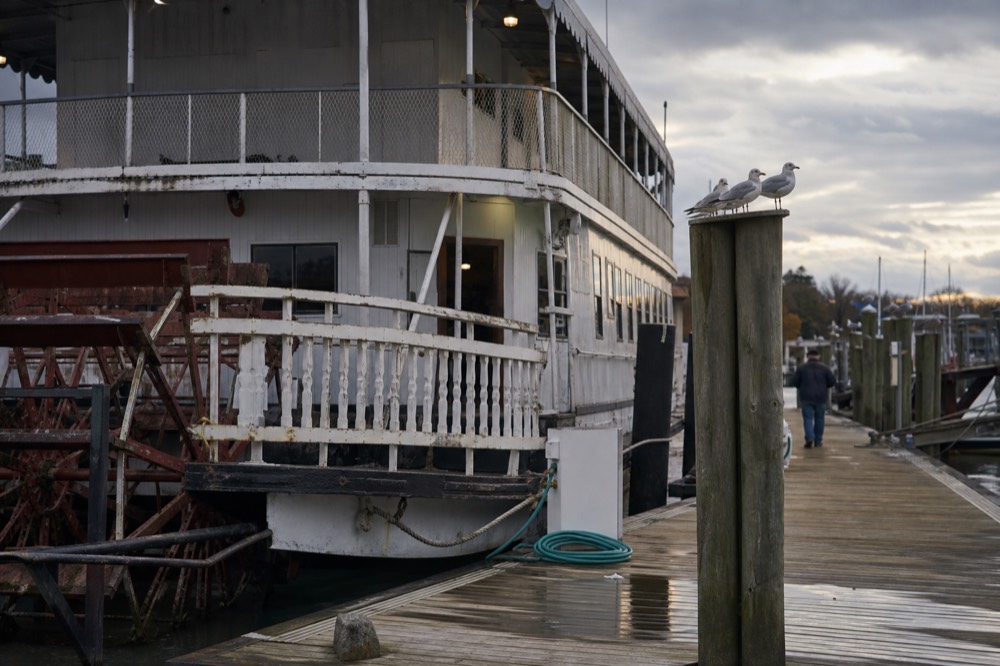 A paddlewheel riverboat docked at a marina in late afternoon light, no text, no logos, no people